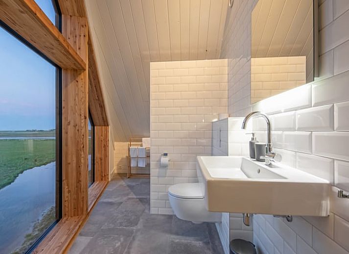 Gemuetliches Wohnzimmer im Ferienhaus in Oosterend, Texel mit Panoramablick auf die Natur.