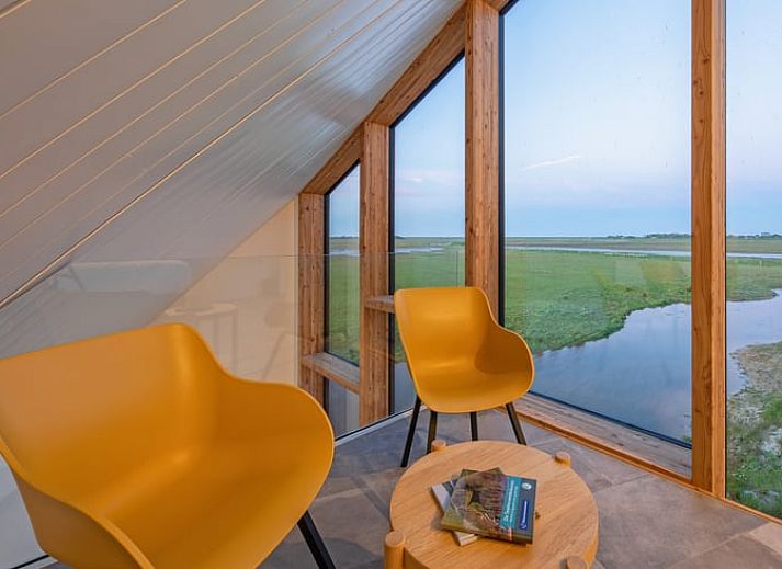 Gemuetliches Wohnzimmer im Ferienhaus in Oosterend, Texel mit Panoramablick auf die Natur.