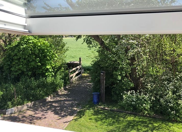 Seitenansicht des Ferienhauses in Oosterend, Texel mit gemuetlicher Sitzecke im Freien.