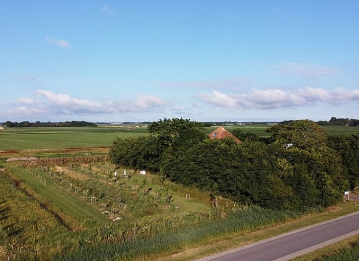 Seitenansicht des Ferienhauses in Oosterend, Texel mit gemuetlicher Sitzecke im Freien.