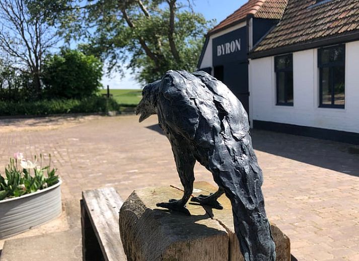 Seitenansicht des Ferienhauses in Oosterend, Texel mit gemuetlicher Sitzecke im Freien.
