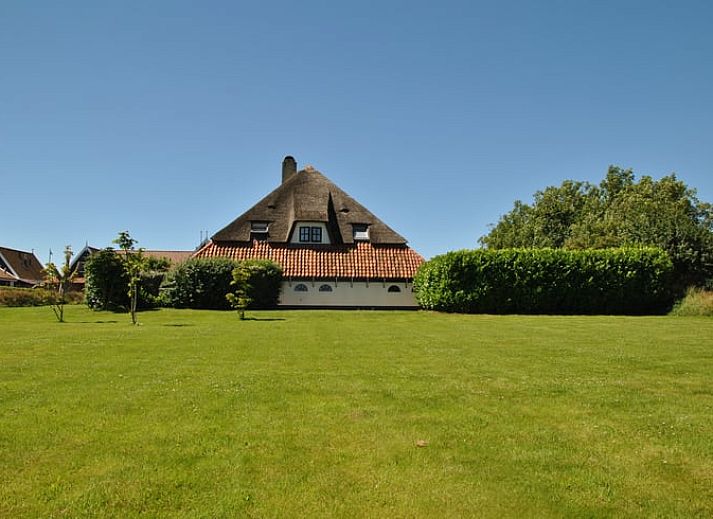Open living space in Holiday home in Oosterend, Texel, with wood stove and dining area.