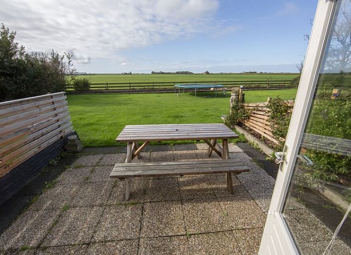 Wooden sign points to guesthouse at Holiday home in Oosterend, Texel. Cozy vacation home on the Wadden Islands.