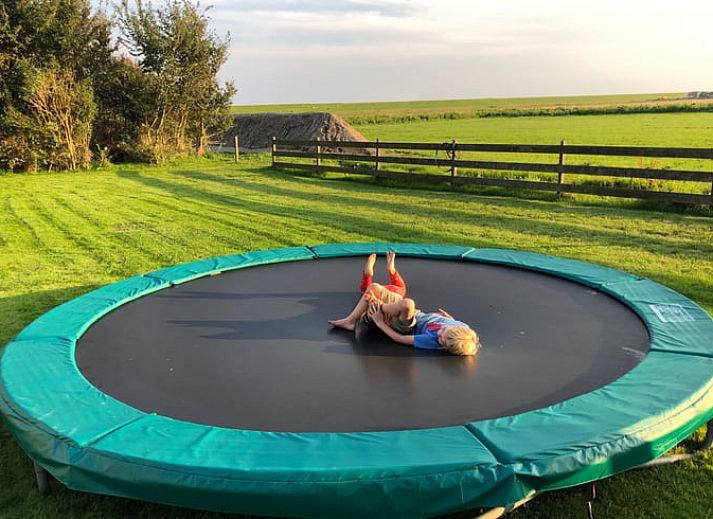 Wooden sign points to guesthouse at Holiday home in Oosterend, Texel. Cozy vacation home on the Wadden Islands.