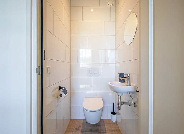 Stijlvolle woonkamer in Vakantiehuis in Oosterend, Texel met moderne inrichting en uitzicht op de tuin.