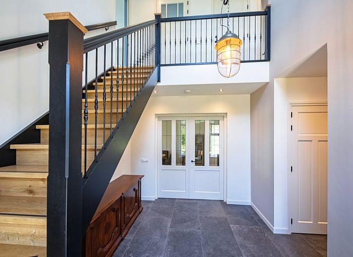 Stijlvolle woonkamer in Vakantiehuis in Oosterend, Texel met moderne inrichting en uitzicht op de tuin.