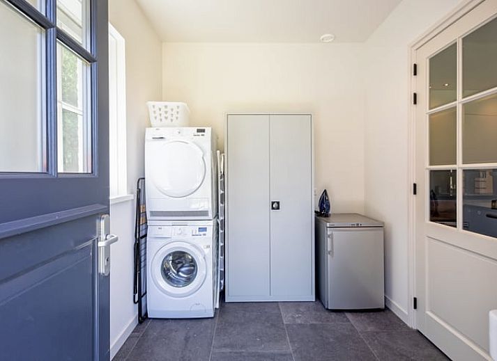Stijlvolle woonkamer in Vakantiehuis in Oosterend, Texel met moderne inrichting en uitzicht op de tuin.