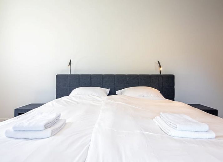 Stijlvolle woonkamer in Vakantiehuis in Oosterend, Texel met moderne inrichting en uitzicht op de tuin.