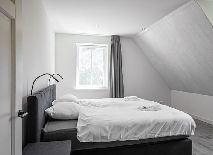 Stijlvolle woonkamer in Vakantiehuis in Oosterend, Texel met moderne inrichting en uitzicht op de tuin.