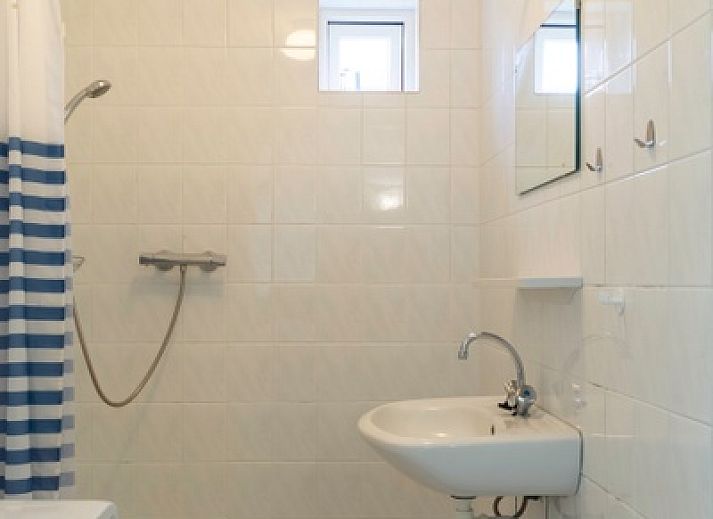 Vorderansicht des Ferienhauses Typ I - Nr. 59 Mallemok in Oosterend, Texel, mit Gartenweg und gruener Umgebung.