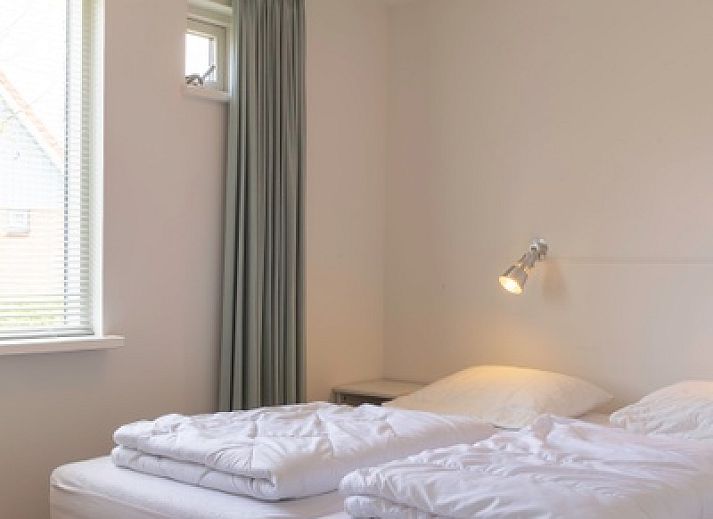 Vorderansicht des Ferienhauses Typ I - Nr. 59 Mallemok in Oosterend, Texel, mit Gartenweg und gruener Umgebung.