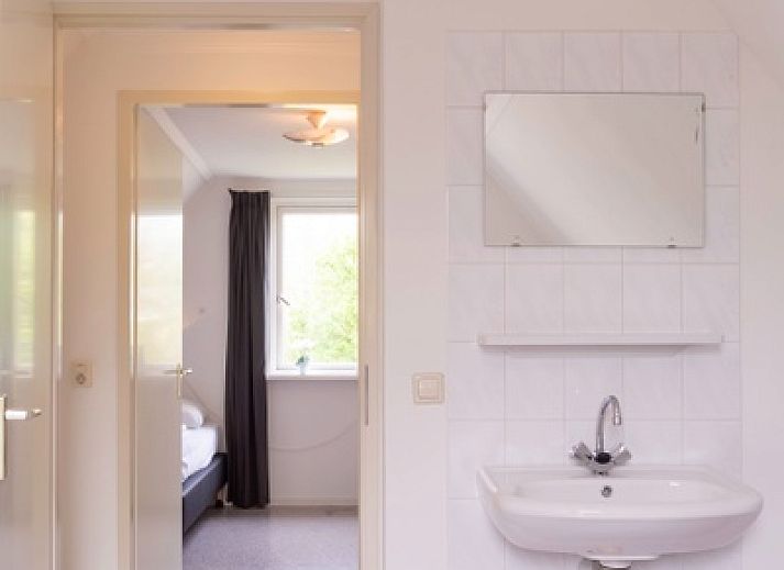 Vorderansicht des Ferienhauses Typ I - Nr. 59 Mallemok in Oosterend, Texel, mit Gartenweg und gruener Umgebung.