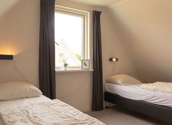 Vorderansicht des Ferienhauses Typ I - Nr. 59 Mallemok in Oosterend, Texel, mit Gartenweg und gruener Umgebung.