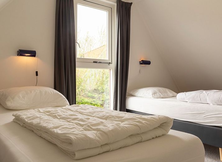 Vorderansicht des Ferienhauses Typ I - Nr. 59 Mallemok in Oosterend, Texel, mit Gartenweg und gruener Umgebung.