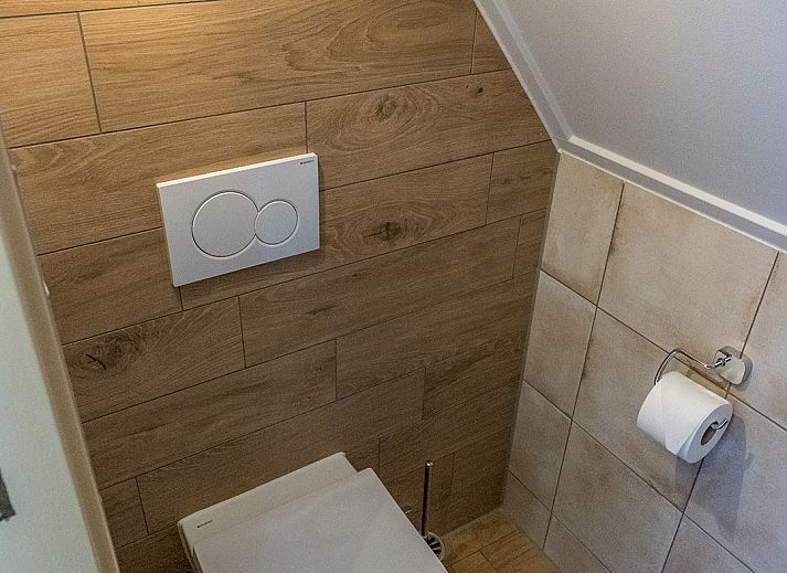 Modern living room in 13 - Dukaat - allotment, vacation home Oosterend, Texel, with sitting area and television.