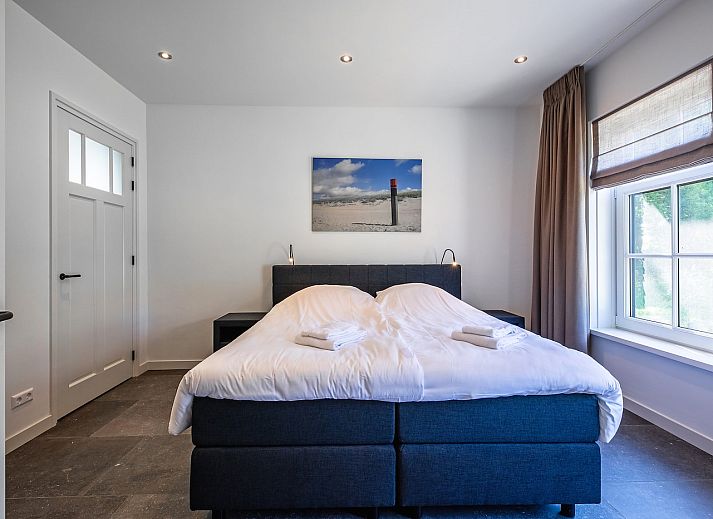 Gezellige woonkamer in vakantiehuis 46 - Nieuw Zeeland, Oosterend, Texel, met comfortabele zitbank.