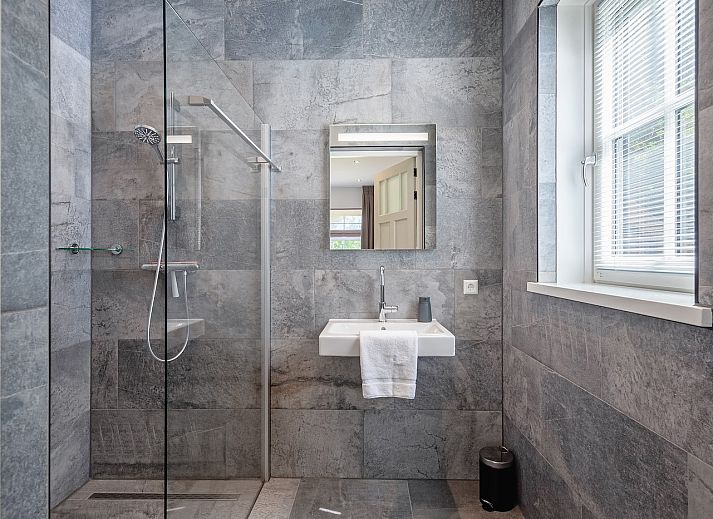 Gezellige woonkamer in vakantiehuis 46 - Nieuw Zeeland, Oosterend, Texel, met comfortabele zitbank.