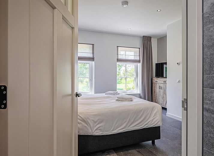 Gezellige woonkamer in vakantiehuis 46 - Nieuw Zeeland, Oosterend, Texel, met comfortabele zitbank.