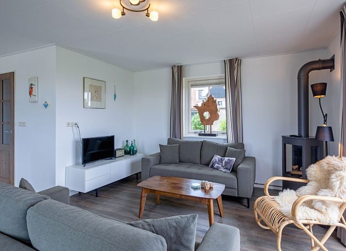 Sonnenterrasse des Ferienhauses De Kokkel in Oosterend Texel mit offenen Tueren zum Innenraum.