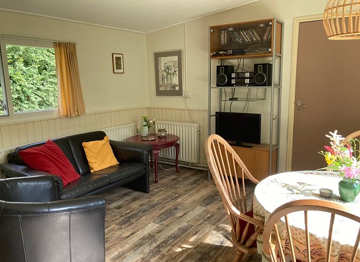 Ferienhaus De Bemes in Oosterend Texel mit gruener Fassade und blumenreichem Garten.