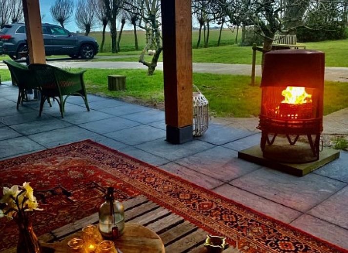 't Kaaps Huussie vacation home in Oosterend Texel with panoramic views of green fields and blue sky.