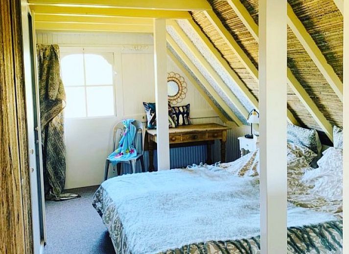 Cozy veranda of 't Kaaps Huussie vacation home in Oosterend Texel, ideal for outdoor relaxation.