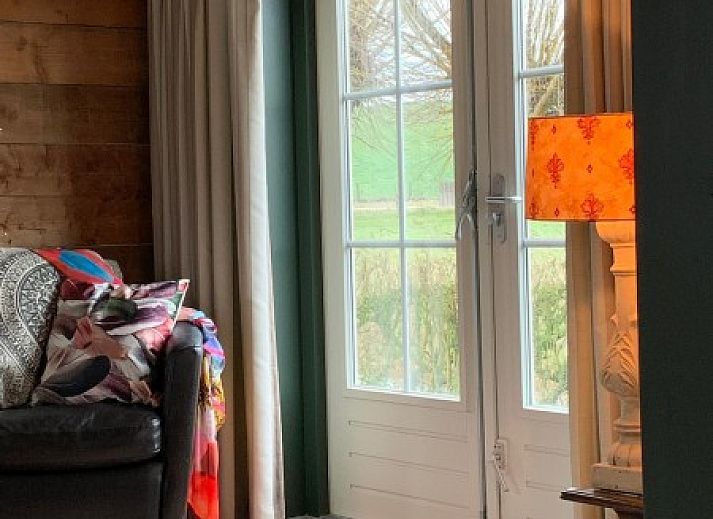 Cozy veranda of 't Kaaps Huussie vacation home in Oosterend Texel, ideal for outdoor relaxation.