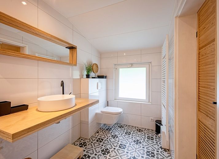 Stylish dining area and open kitchen in vacation home Bungalowpark De Toes - Zeewier, Oosterend, Texel, ideal for family dinners.