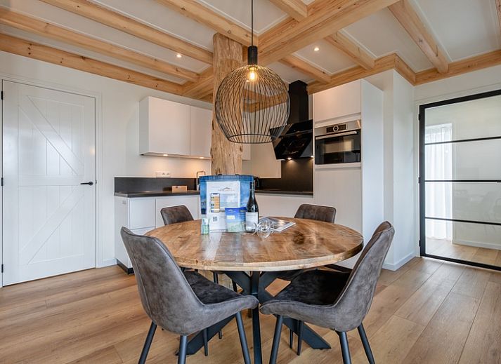 Stylish living room of Apartment C in Oudeschild, Texel with wooden beams and modern furniture.