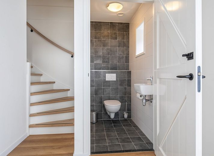 Stylish living room of Apartment C in Oudeschild, Texel with wooden beams and modern furniture.