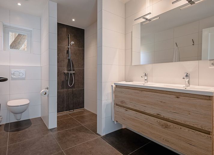 Stylish living room of Apartment C in Oudeschild, Texel with wooden beams and modern furniture.