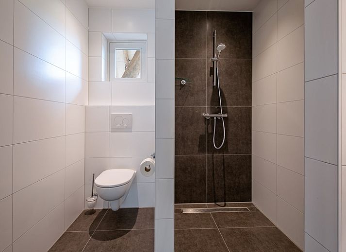 Stylish living room of Apartment C in Oudeschild, Texel with wooden beams and modern furniture.