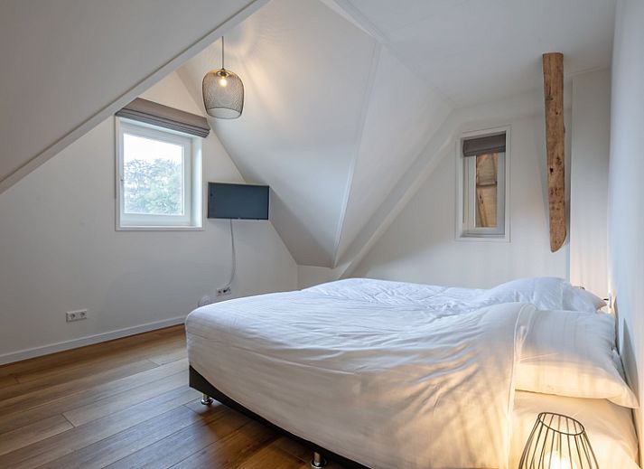 Stylish living room of Apartment C in Oudeschild, Texel with wooden beams and modern furniture.