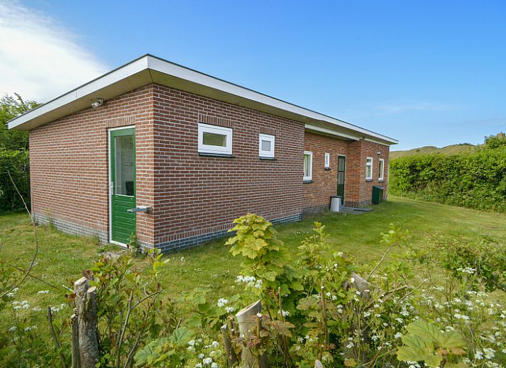 Terras bij Bungalowpark Slufteroord - Slufterbungalows 362 in Zuid-Eierland, Texel met uitzicht op groene tuin.