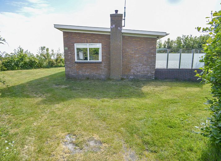 Terras bij Bungalowpark Slufteroord - Slufterbungalows 362 in Zuid-Eierland, Texel met uitzicht op groene tuin.