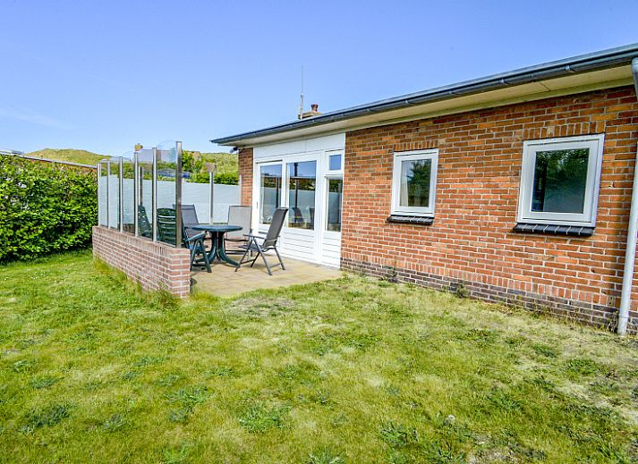 Terras bij Bungalowpark Slufteroord - Slufterbungalows 362 in Zuid-Eierland, Texel met uitzicht op groene tuin.