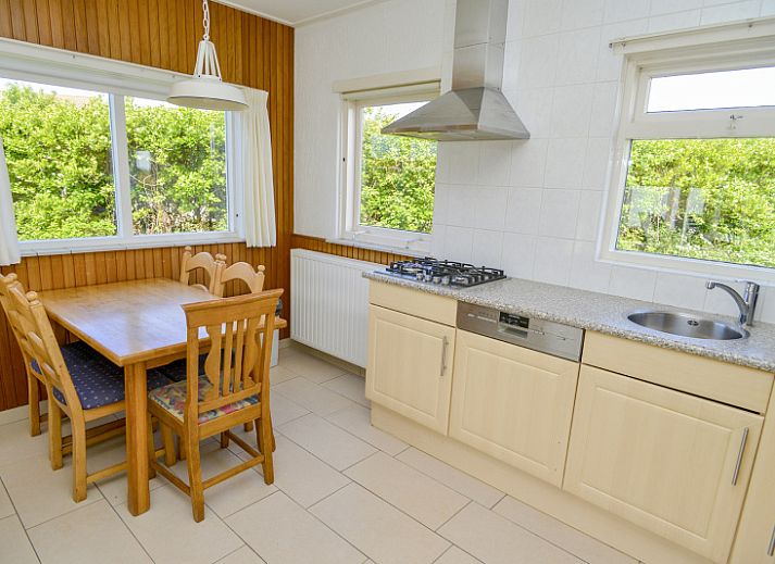 Achtertuin van vakantiehuis Slufterbungalows 362 in Bungalowpark Slufteroord, Texel omgeven door weelderige natuur.