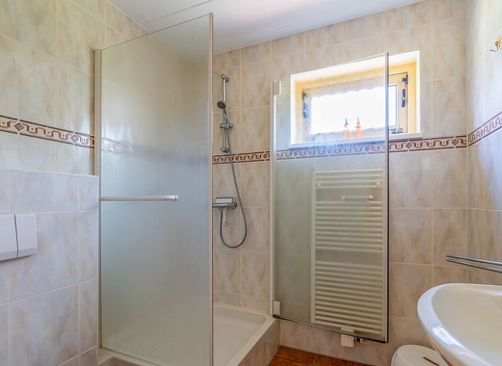 Gezellige woonkamer van De Vijf Sterren vakantiehuis in Zuid-Eierland, Texel met comfortabele zithoek en natuurlijk licht.