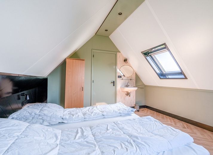 Gezellige woonkamer van De Vijf Sterren vakantiehuis in Zuid-Eierland, Texel met comfortabele zithoek en natuurlijk licht.