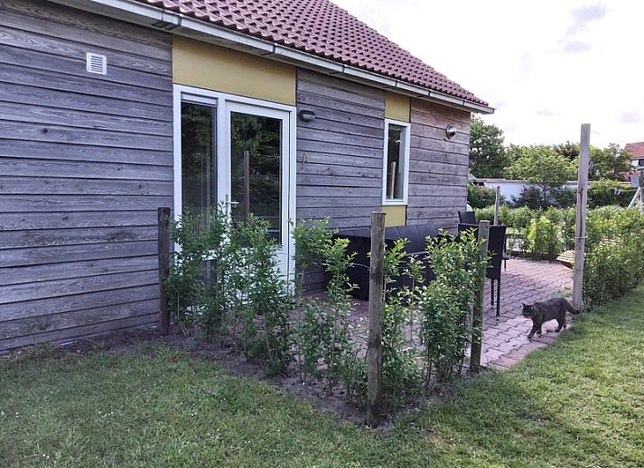 De Triaan vakantiewoningen in Zuid-Eierland, Texel, offers a charming vacation home with wooden facade and spacious garden.