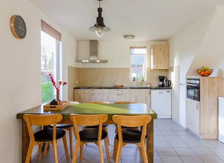 De Triaan vakantiewoningen in Zuid-Eierland, Texel, offers a charming vacation home with wooden facade and spacious garden.