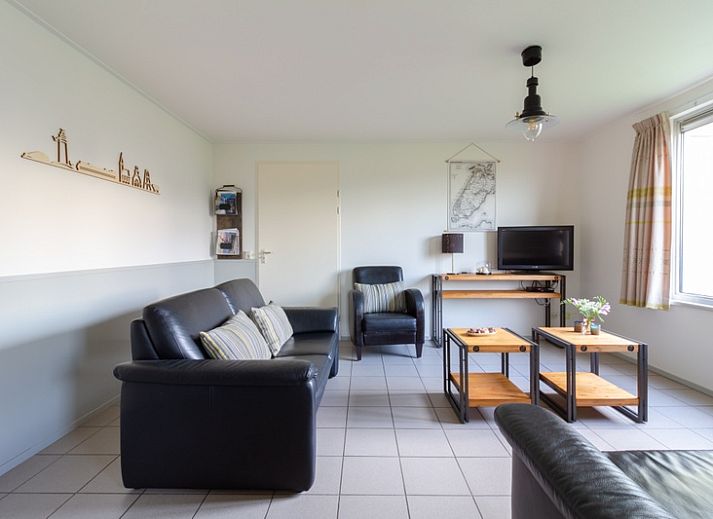 De Triaan vakantiewoningen in Zuid-Eierland, Texel, offers a charming vacation home with wooden facade and spacious garden.