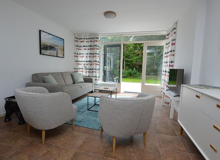 Ferienhaus de Parel 182 in De Dennen, Texel mit sonniger Terrasse und gruener Umgebung.