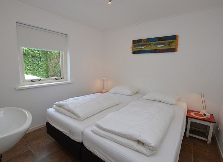 Gemuetliches Wohnzimmer des Ferienhauses de Parel 182 in De Dennen, Texel mit Blick auf den Garten.