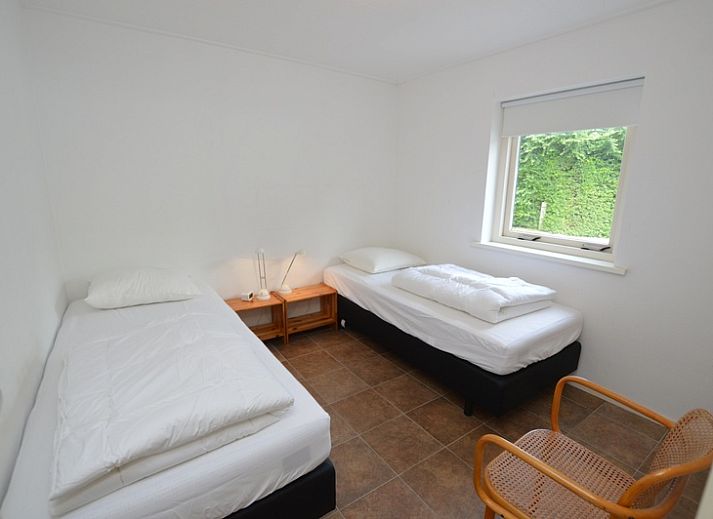 Gemuetliches Wohnzimmer des Ferienhauses de Parel 182 in De Dennen, Texel mit Blick auf den Garten.