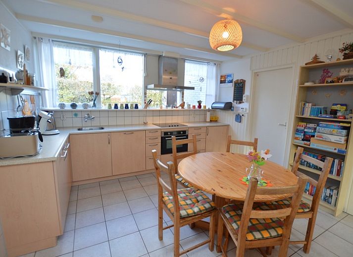 Gezellige woonkamer in Vakantiehuis de Parel 212, De Dennen, Texel met uitzicht op groene omgeving.