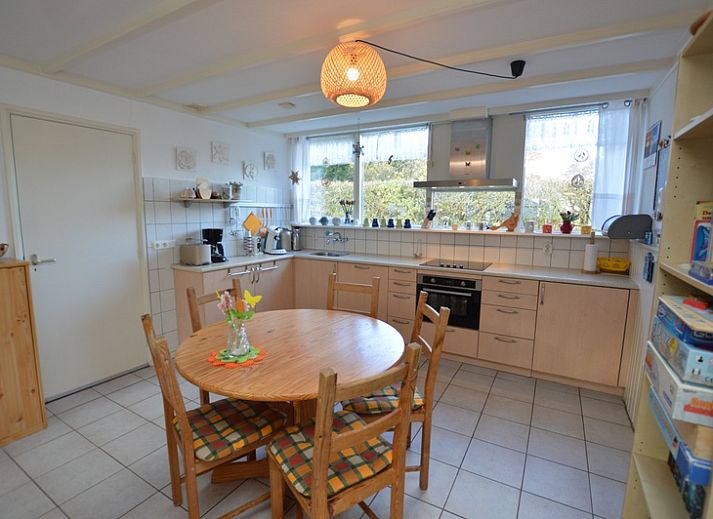 Gezellige woonkamer in Vakantiehuis de Parel 212, De Dennen, Texel met uitzicht op groene omgeving.