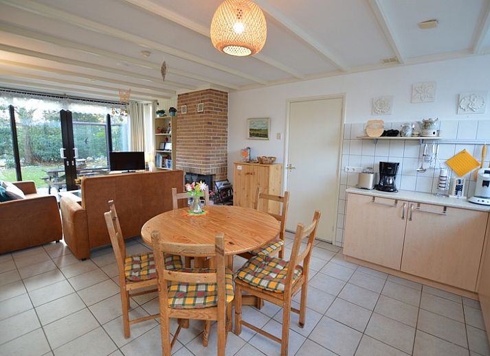 Gezellige woonkamer in Vakantiehuis de Parel 212, De Dennen, Texel met uitzicht op groene omgeving.