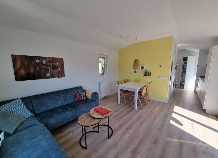 Ferienpark de Bremakker - Bosveld 135, Ferienhaus in De Dennen, Texel, umgeben von gruener Natur und blauem Himmel.