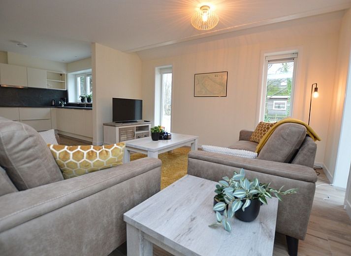 Ferienhaus De Nagtegaal 23 in De Dennen, Texel, umgeben von Natur mit einer sonnigen Terrasse.